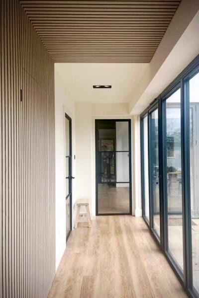 Contemporary slatted wall in hall of Worcester home renovation by Megan Ace Interiors