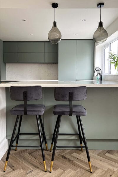 Contemporary kitchen in Worcester with soft green units and statement seating by Megan Ace