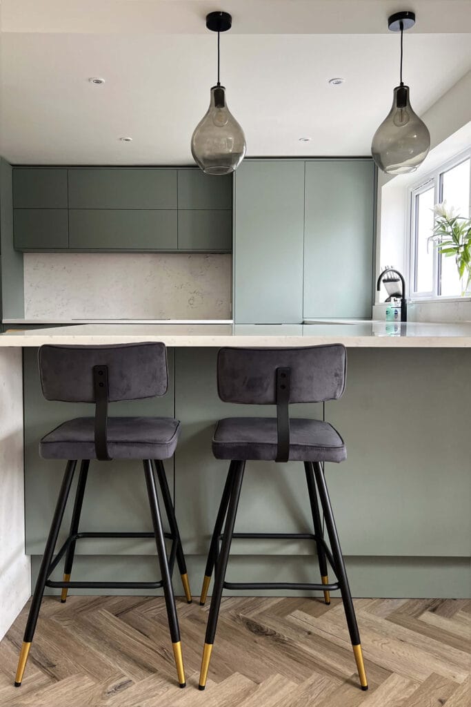 Contemporary kitchen in Worcester with soft green units and statement seating by Megan Ace